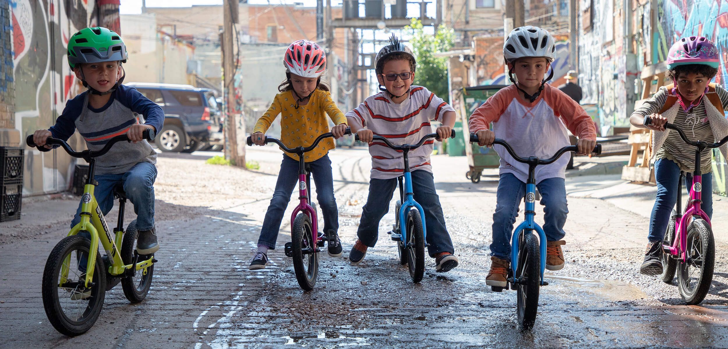 Friends riding bikes together in alley