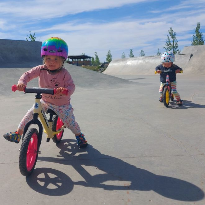 Two children ride and stride on Strider 12" Sport balance bikes