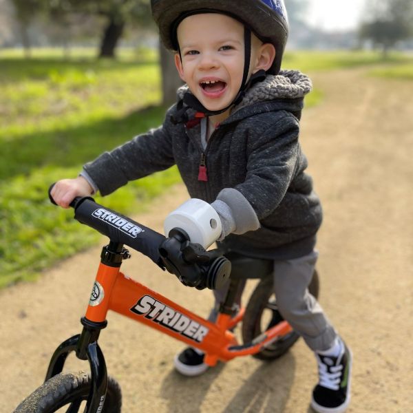 Ryder Morgan smiles as he rides his adaptive Strider 12 Sport